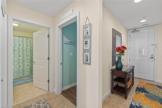 hall featuring light tile patterned floors