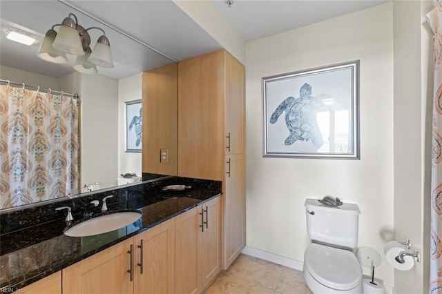 bathroom with tile patterned flooring, vanity, toilet, and a chandelier