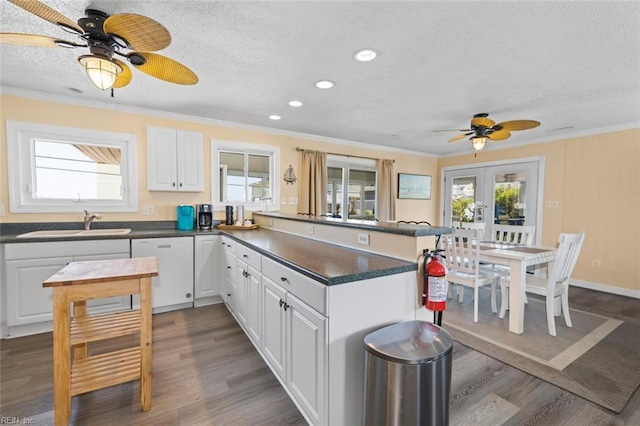 kitchen with french doors, ornamental molding, white dishwasher, sink, and white cabinets