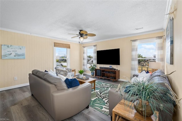 living room featuring wood-type flooring, plenty of natural light, and ornamental molding