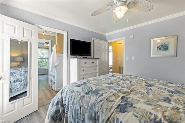 bedroom with light hardwood / wood-style floors, ceiling fan, and ornamental molding