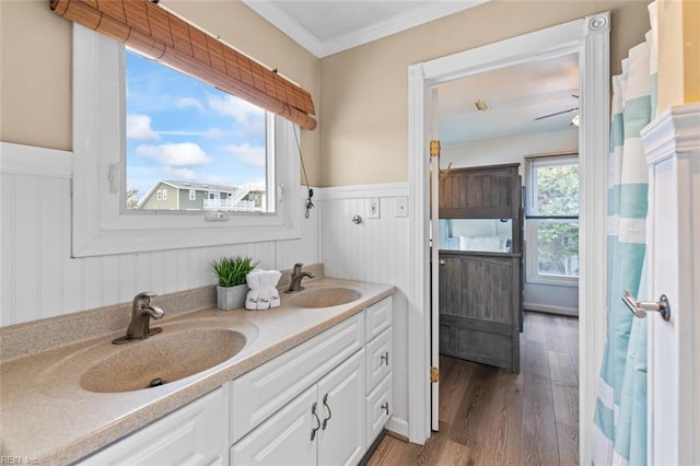 bathroom featuring hardwood / wood-style floors, vanity, ceiling fan, and crown molding