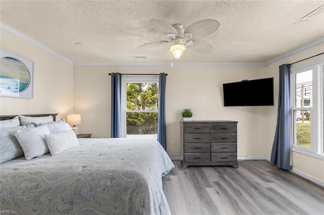 bedroom featuring ceiling fan, crown molding, a textured ceiling, and light wood-type flooring