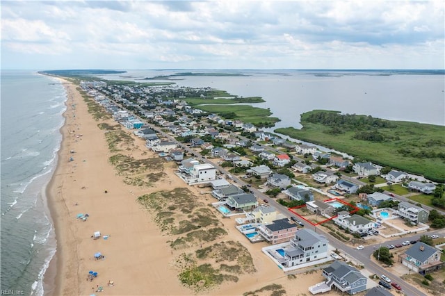 birds eye view of property featuring a water view and a beach view