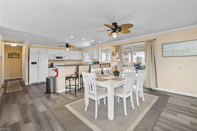 dining room with hardwood / wood-style floors, a textured ceiling, ceiling fan, and crown molding