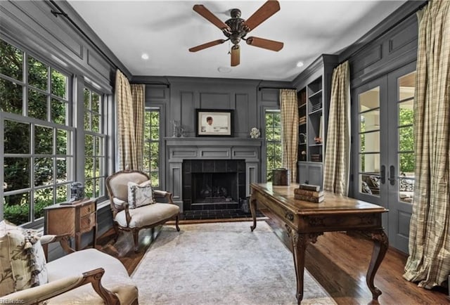 living area featuring french doors, plenty of natural light, and wood-type flooring