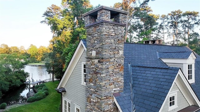 view of side of property featuring a water view and a lawn