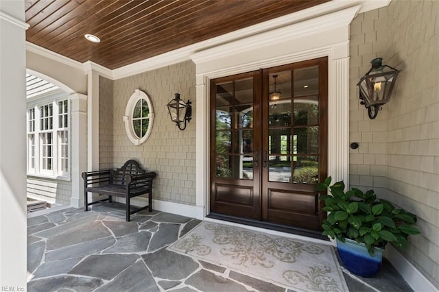 doorway to property featuring covered porch and french doors