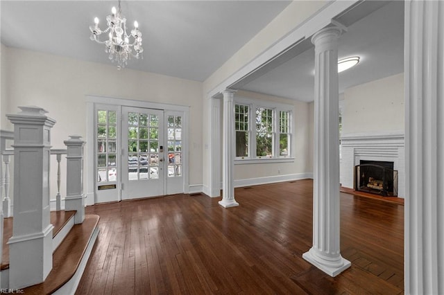 interior space featuring plenty of natural light, a chandelier, decorative columns, and dark hardwood / wood-style floors