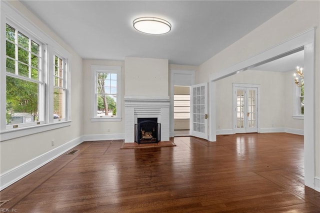 unfurnished living room with a fireplace, french doors, and hardwood / wood-style floors