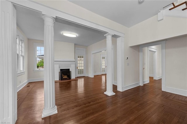 unfurnished living room with beamed ceiling, decorative columns, and dark wood-type flooring