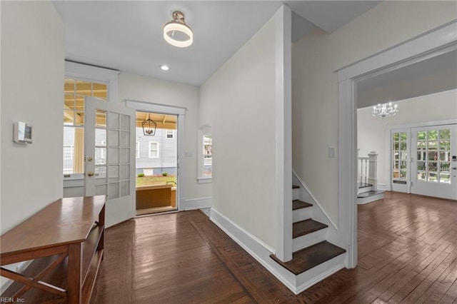 foyer entrance featuring a chandelier and dark wood-type flooring