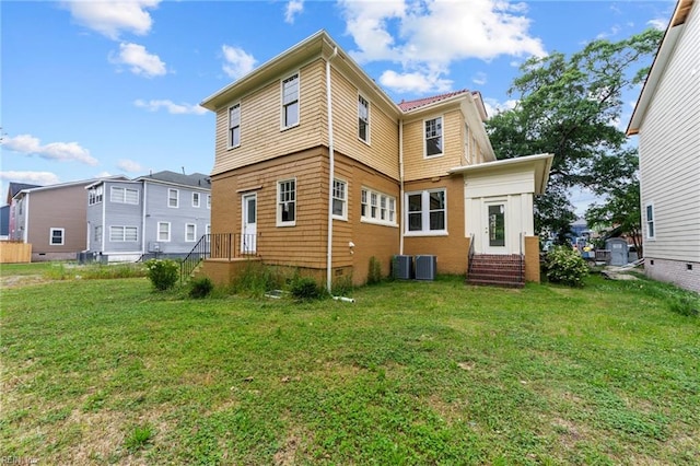 back of property featuring central AC and a lawn