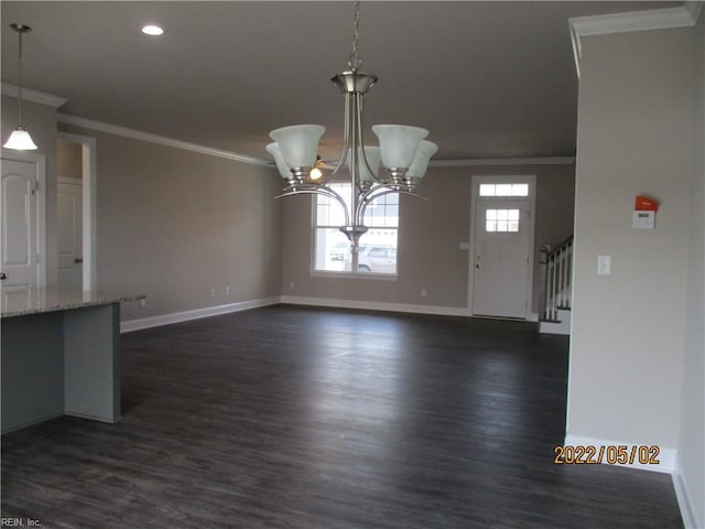 unfurnished dining area featuring ornamental molding, dark wood-type flooring, and a chandelier