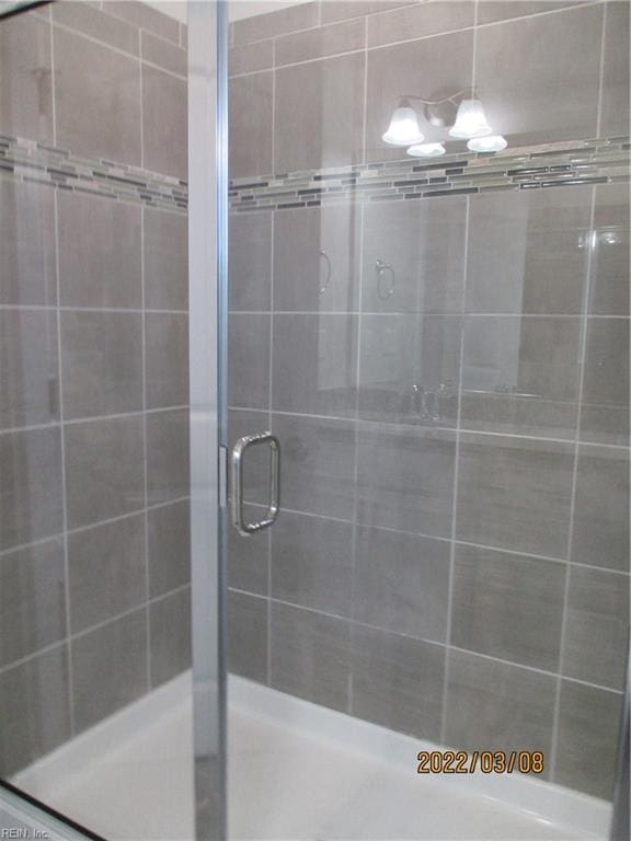 bathroom with a shower with door