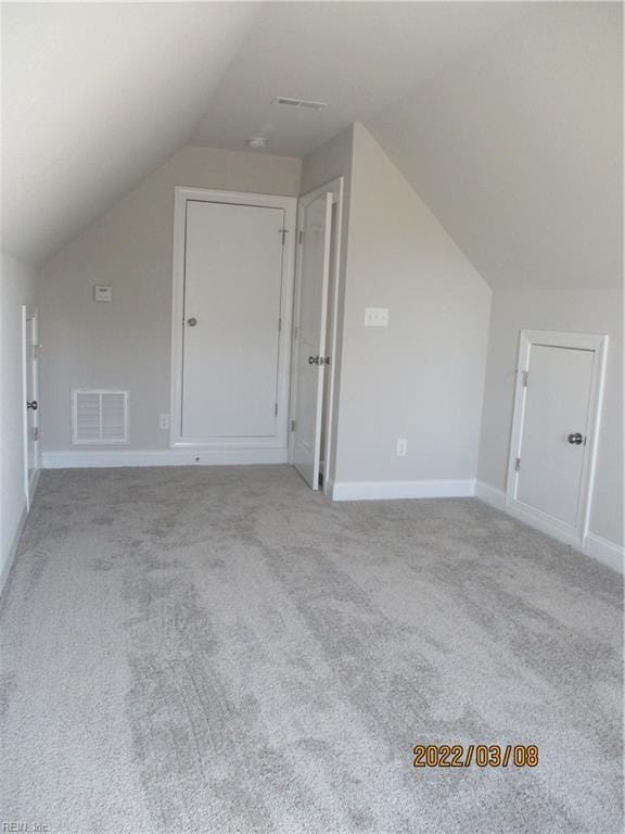 additional living space with lofted ceiling and light carpet