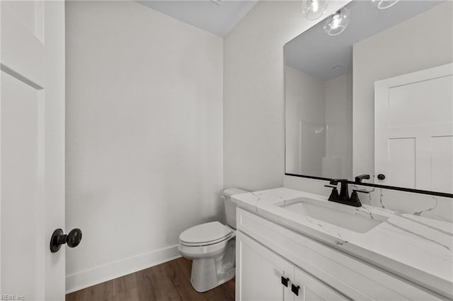 bathroom with wood-type flooring, toilet, and vanity