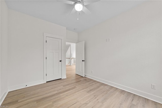 empty room with ceiling fan and light hardwood / wood-style flooring