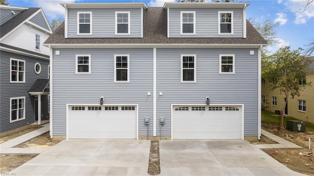 view of front facade with a garage and central air condition unit