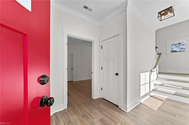 foyer entrance with light wood-type flooring and ornamental molding