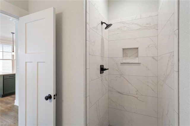 bathroom featuring tiled shower and hardwood / wood-style flooring