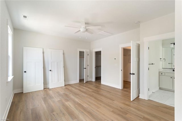 unfurnished bedroom featuring ceiling fan, light hardwood / wood-style flooring, and ensuite bath