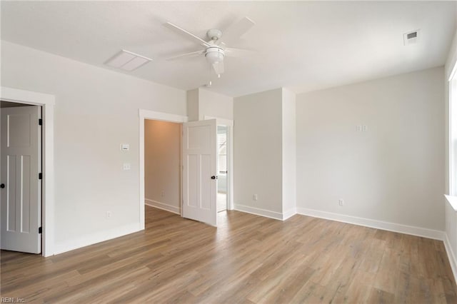 empty room with ceiling fan and light hardwood / wood-style flooring