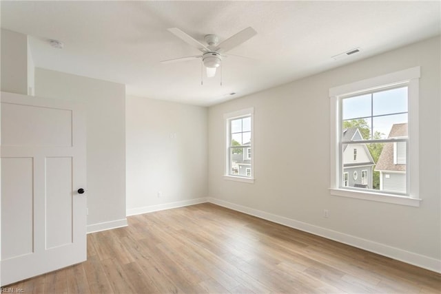 spare room featuring ceiling fan, a healthy amount of sunlight, and light hardwood / wood-style floors