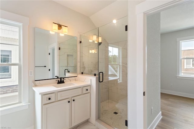 bathroom featuring vaulted ceiling, wood-type flooring, walk in shower, and vanity