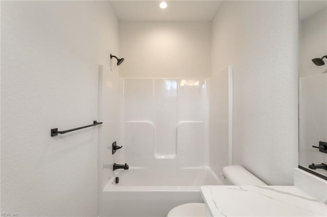 bathroom featuring tub / shower combination and toilet