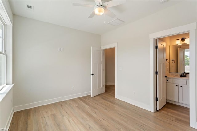 unfurnished bedroom with ceiling fan, sink, connected bathroom, and light hardwood / wood-style floors