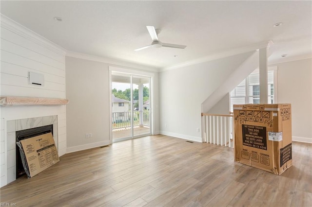 unfurnished living room featuring ceiling fan, light hardwood / wood-style flooring, ornamental molding, and a fireplace