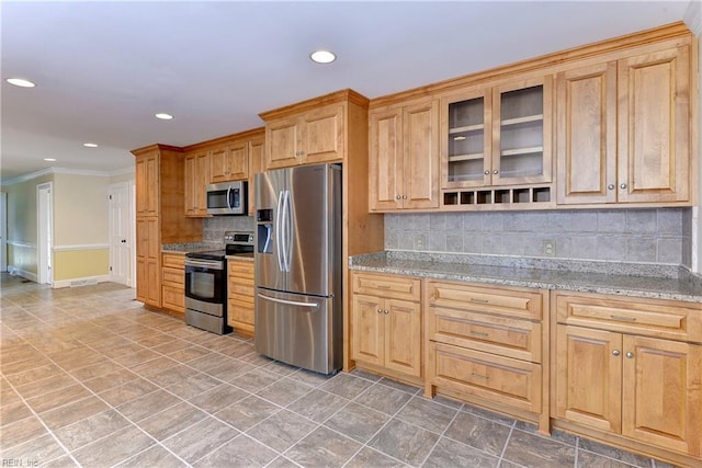 kitchen featuring backsplash, crown molding, light stone counters, and stainless steel appliances