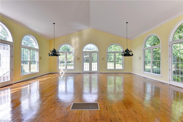 interior space featuring a healthy amount of sunlight, crown molding, and a chandelier