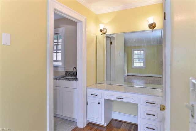 bathroom featuring vanity, hardwood / wood-style flooring, plenty of natural light, and crown molding