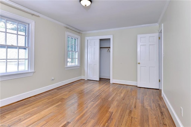 unfurnished bedroom with crown molding, a closet, and hardwood / wood-style flooring