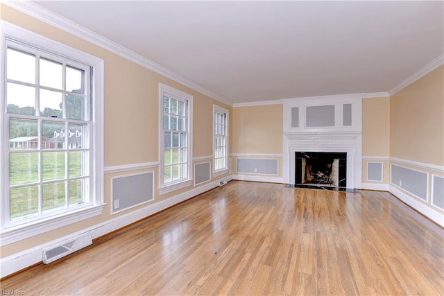 unfurnished living room with ornamental molding and a wealth of natural light