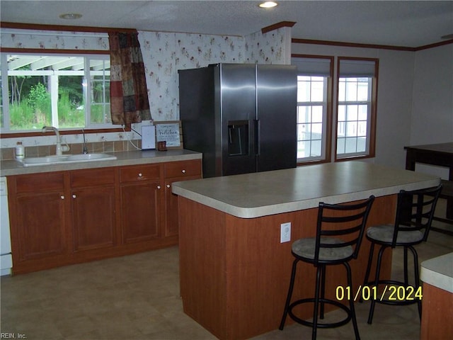 34026 Doctors Rd, Newsoms, VA 23874 - kitchen featuring a sink, crown molding, fridge with ice dispenser, brown cabinets, and light countertops
