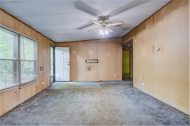 carpeted spare room featuring a ceiling fan