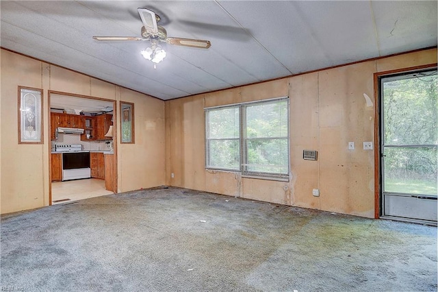 carpeted empty room featuring vaulted ceiling and a ceiling fan