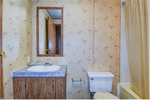 full bathroom featuring toilet, vanity, and wallpapered walls