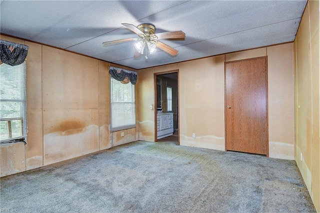 unfurnished bedroom with ceiling fan and carpet