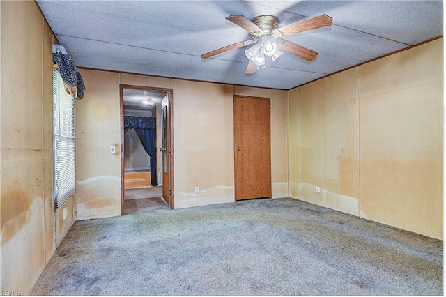 unfurnished room with ceiling fan and carpet flooring