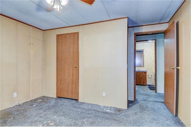 unfurnished room with ceiling fan and ornamental molding