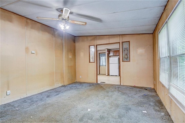 spare room featuring lofted ceiling, carpet, and ceiling fan