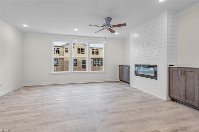 unfurnished living room with light hardwood / wood-style flooring, a fireplace, ornamental molding, and ceiling fan