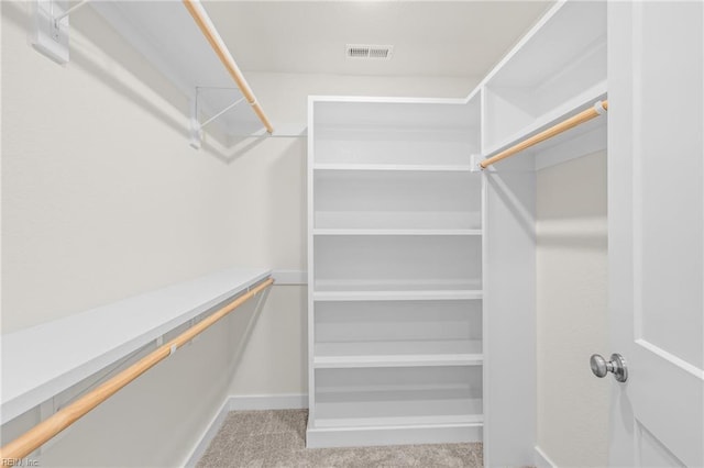 walk in closet featuring light carpet