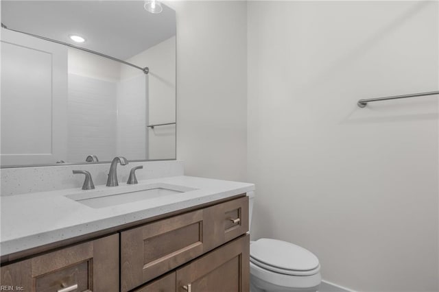 bathroom with walk in shower, vanity, and toilet