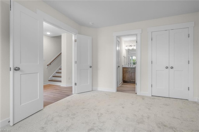 unfurnished bedroom featuring carpet floors, ensuite bath, and a closet