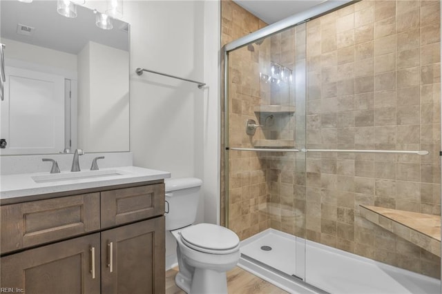 bathroom featuring vanity, wood-type flooring, toilet, and walk in shower